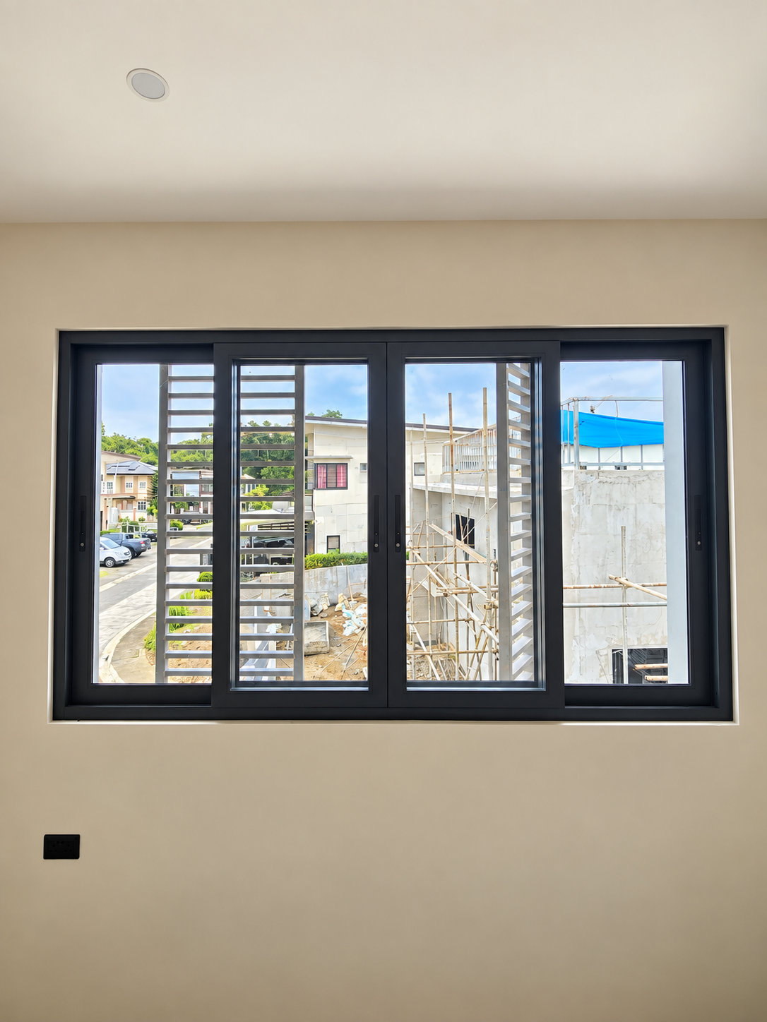 OTEC Window Installation Update in Lipa, Batangas Four glass panels within a dark aluminium sliding window frame.