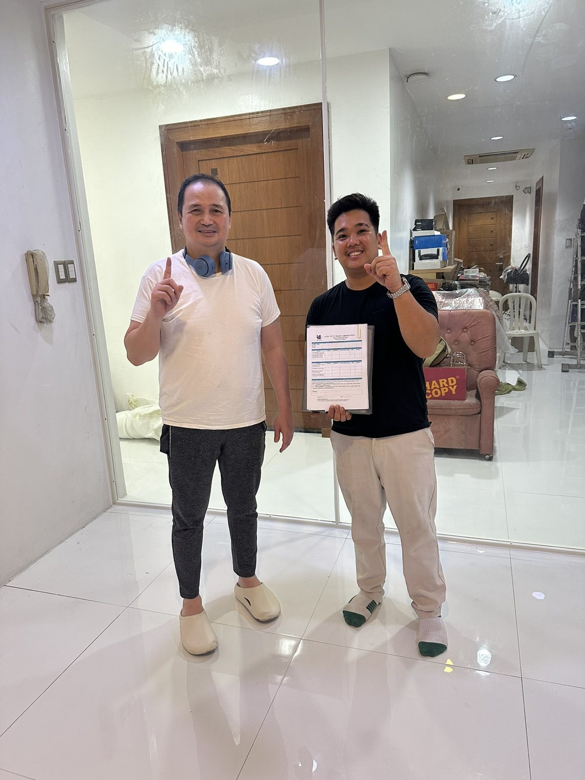 A client and an OTEC installer holding the signed job completion form on site.